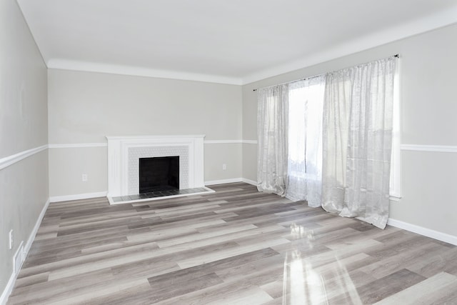 unfurnished living room with a tile fireplace and light hardwood / wood-style floors