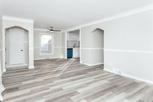 unfurnished living room with ceiling fan, light wood-type flooring, and sink