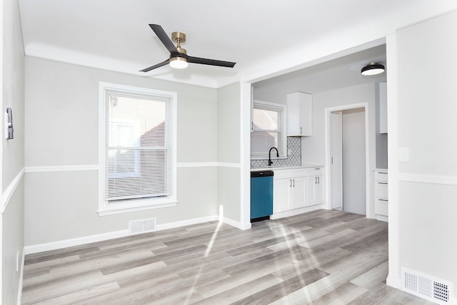 interior space with a wealth of natural light, light hardwood / wood-style flooring, ceiling fan, and sink