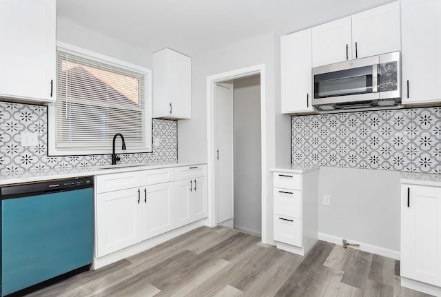 kitchen featuring sink, decorative backsplash, appliances with stainless steel finishes, light hardwood / wood-style floors, and white cabinetry