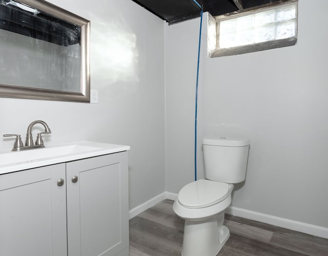 bathroom with toilet, vanity, and hardwood / wood-style flooring