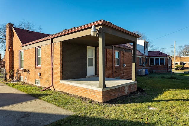 view of side of home featuring central air condition unit and a lawn