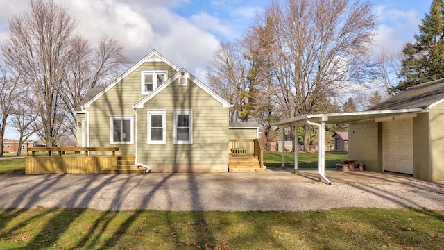 back of property with a garage and a wooden deck