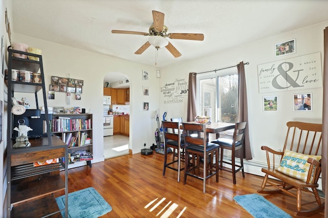 dining area with wood-type flooring and ceiling fan