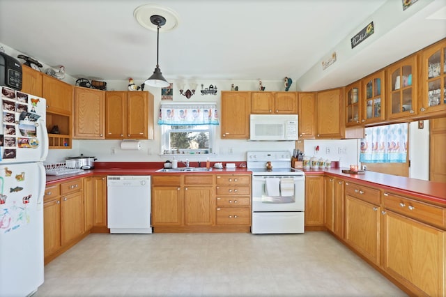 kitchen with hanging light fixtures, white appliances, and sink