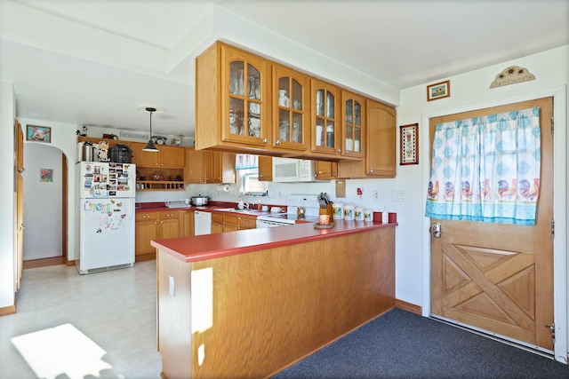 kitchen with white appliances, decorative light fixtures, and kitchen peninsula