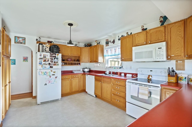 kitchen with sink, white appliances, and decorative light fixtures