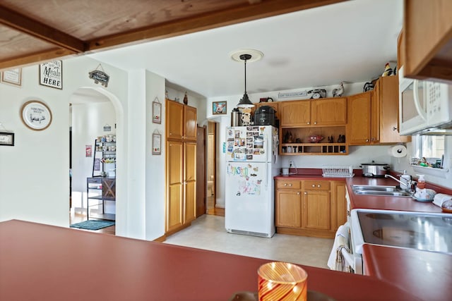 kitchen featuring beamed ceiling, sink, white appliances, and decorative light fixtures