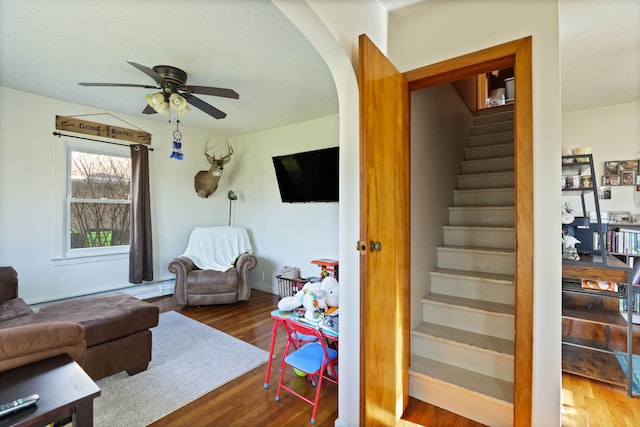 living room featuring wood-type flooring and ceiling fan