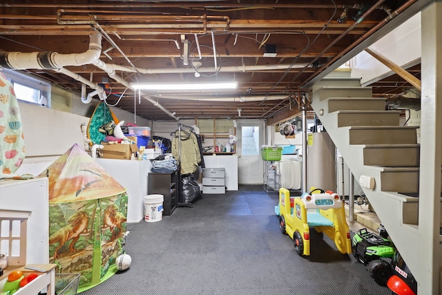 basement with a healthy amount of sunlight and water heater