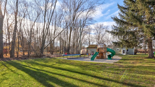 view of yard with a trampoline, an outdoor structure, and a playground