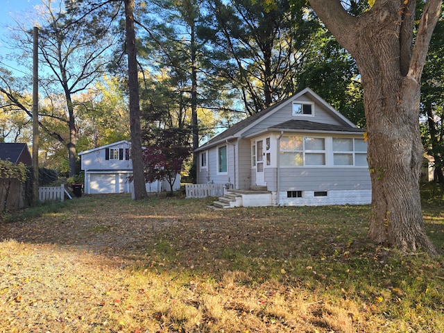 view of front of house featuring a garage and an outbuilding