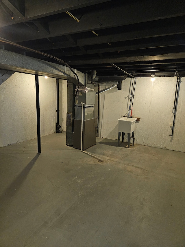 basement featuring sink and heating unit