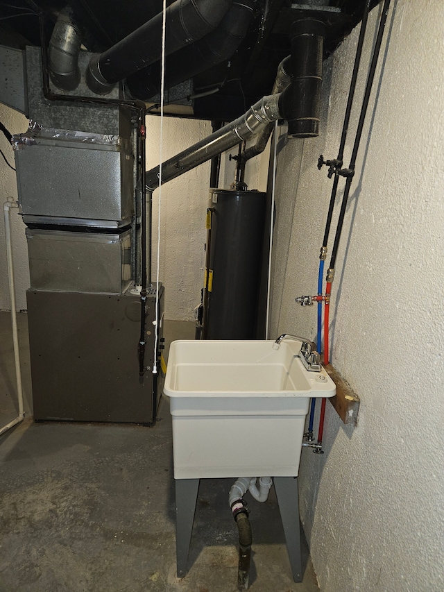 utility room with water heater and sink