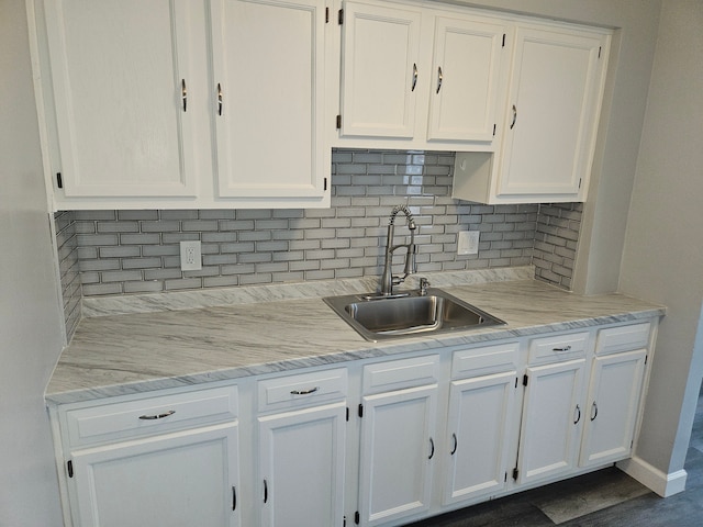 kitchen featuring white cabinets, backsplash, sink, and hardwood / wood-style flooring