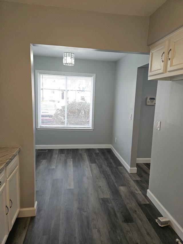 unfurnished dining area featuring dark hardwood / wood-style floors