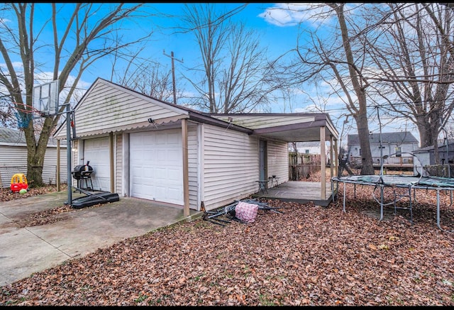 view of side of property featuring a garage and a trampoline