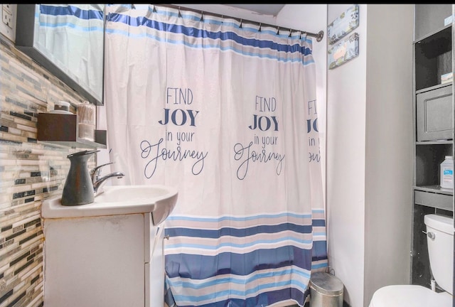 bathroom featuring decorative backsplash, vanity, toilet, and walk in shower