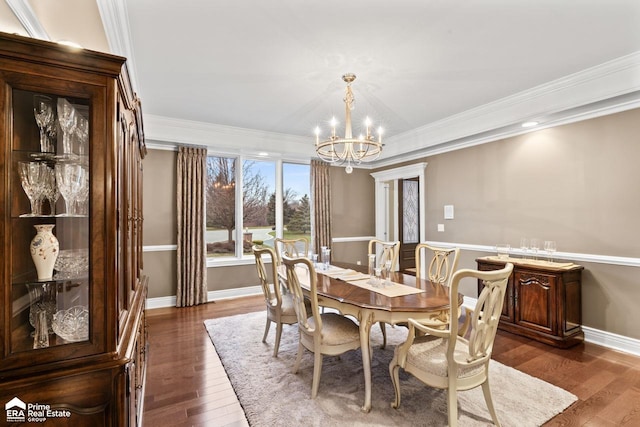 dining area with dark hardwood / wood-style floors, an inviting chandelier, and crown molding