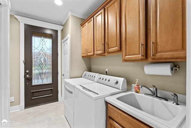 laundry area featuring sink, cabinets, light tile patterned flooring, washer and dryer, and ornamental molding