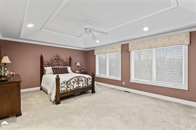 carpeted bedroom with a raised ceiling, ceiling fan, and ornamental molding