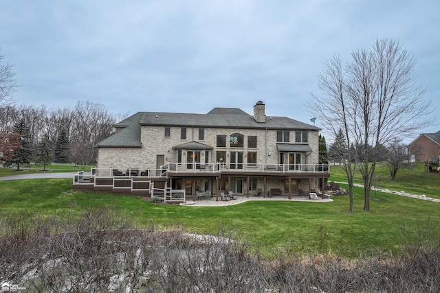 rear view of property featuring a patio area, a yard, and a deck