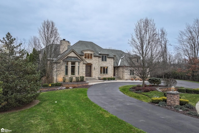 french country style house featuring a front yard