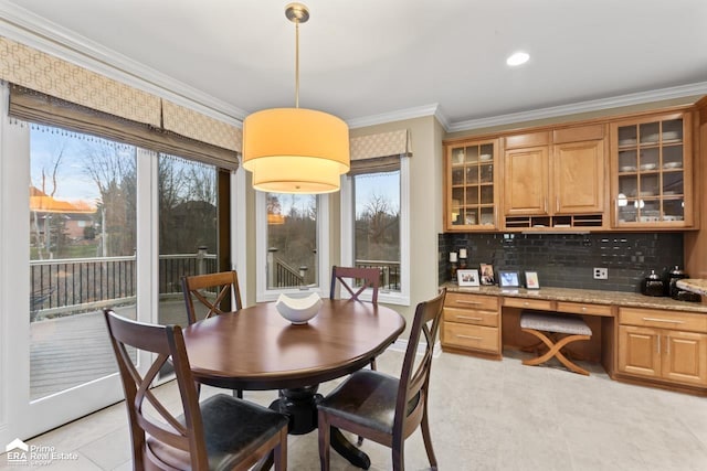 dining area with a healthy amount of sunlight, light tile patterned flooring, and crown molding