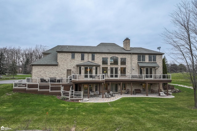 back of property featuring a patio area, a yard, and a deck