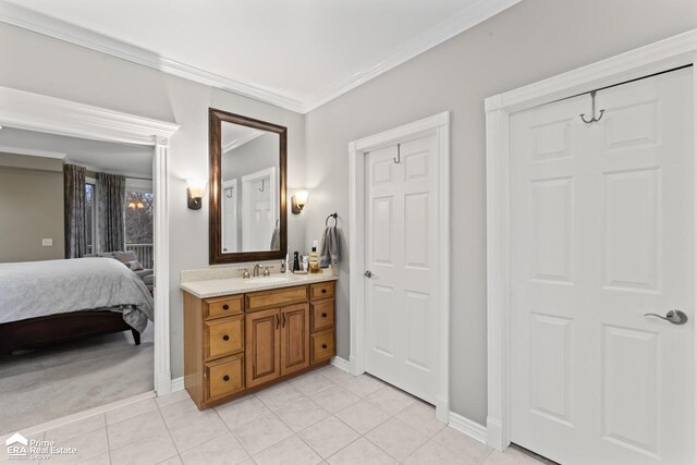 bathroom with tile patterned flooring, vanity, and crown molding