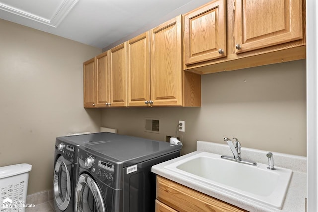 clothes washing area featuring tile patterned floors, washer and dryer, sink, and cabinets