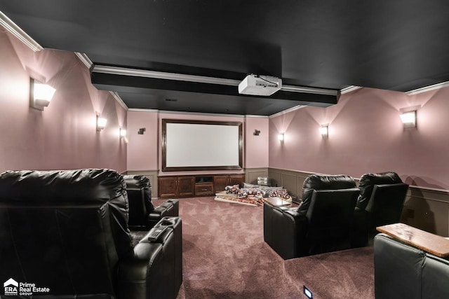 carpeted home theater with beamed ceiling and ornamental molding