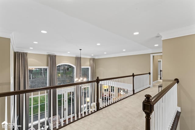 hall with carpet flooring, ornamental molding, and an inviting chandelier