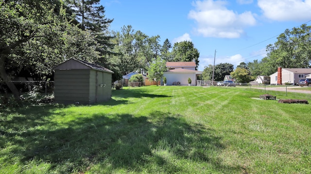 view of yard with a shed and an outdoor fire pit