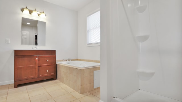 bathroom featuring tile patterned flooring, vanity, and a relaxing tiled tub