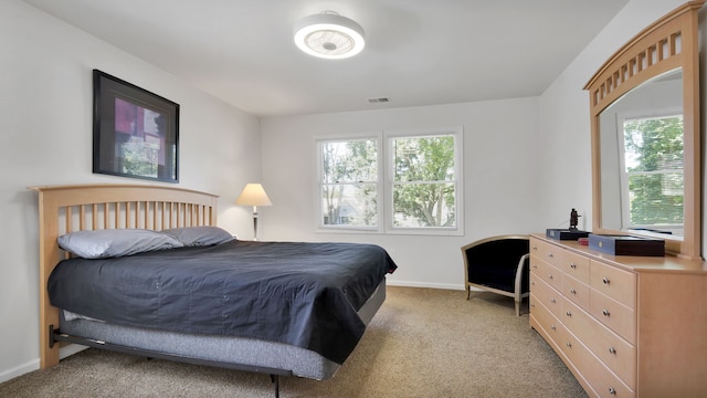 bedroom with light colored carpet and multiple windows