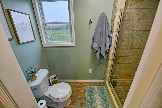 bathroom with a shower with door and toilet