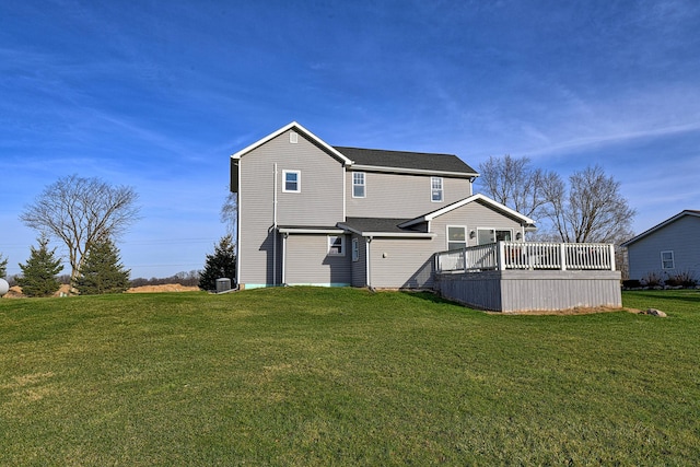 back of property with a wooden deck and a lawn