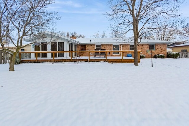 snow covered house with a deck