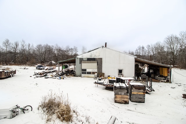 snow covered rear of property with an outbuilding