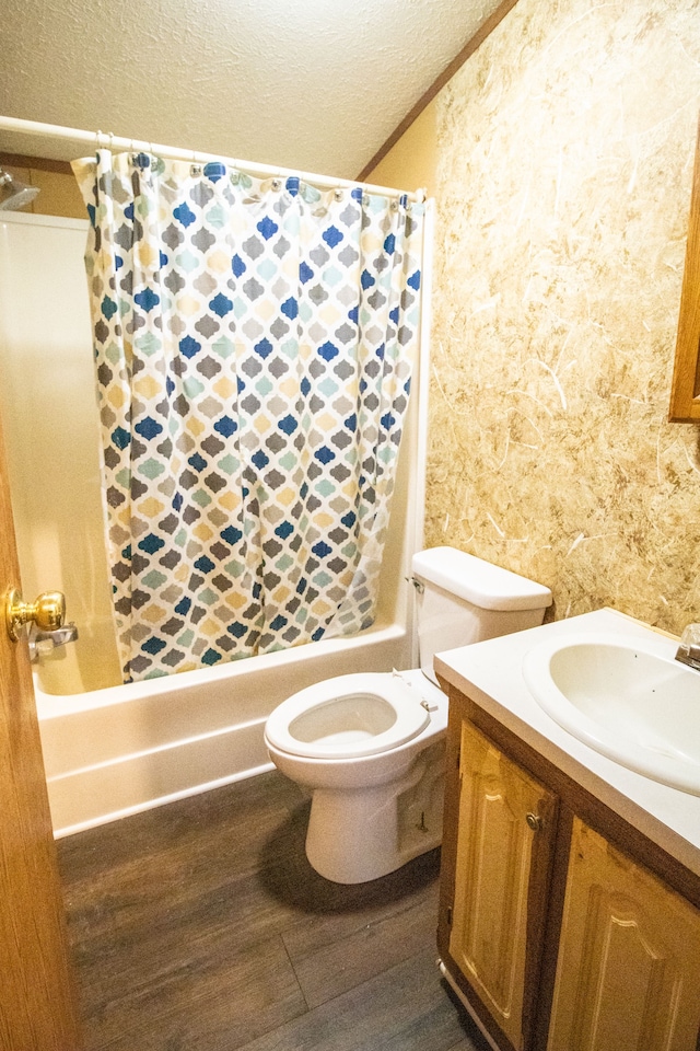 full bathroom featuring toilet, a textured ceiling, vanity, shower / bathtub combination with curtain, and hardwood / wood-style flooring