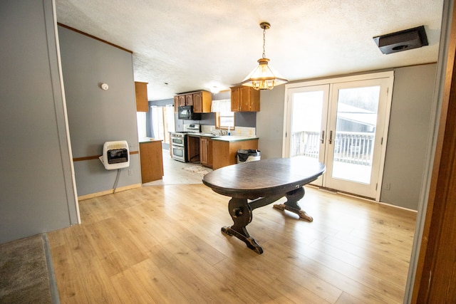 dining space featuring a wealth of natural light, heating unit, a textured ceiling, and french doors