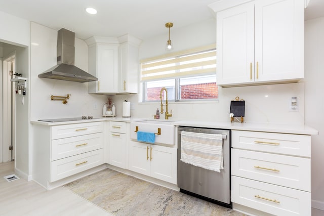 kitchen with stainless steel dishwasher, wall chimney exhaust hood, white cabinetry, and sink