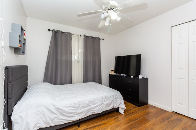 bedroom with ceiling fan, dark wood-type flooring, and a closet