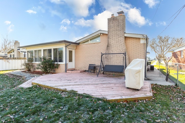 back of house with a sunroom, a yard, and a deck