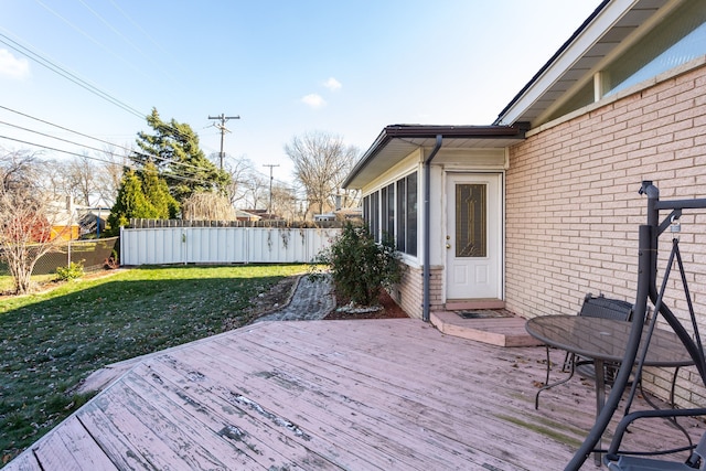 deck with a lawn and a sunroom