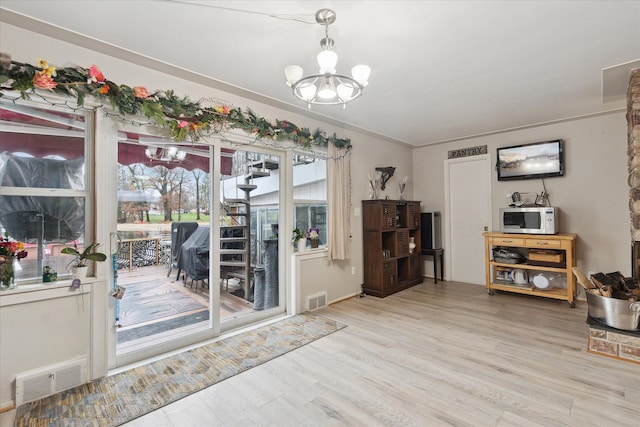 entryway with a notable chandelier and light hardwood / wood-style floors