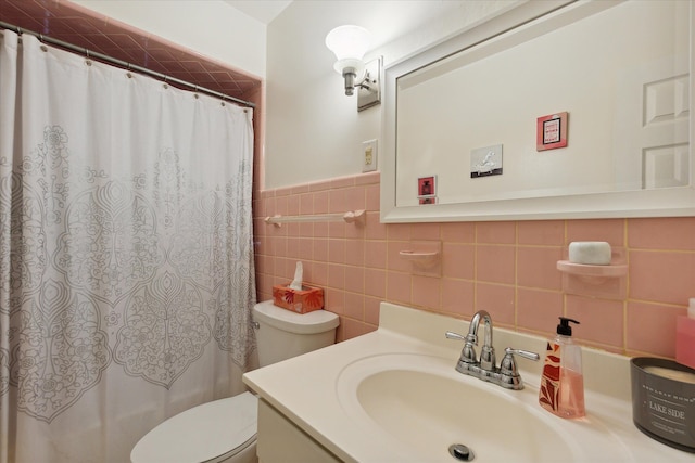 bathroom featuring vanity, toilet, tile walls, and walk in shower