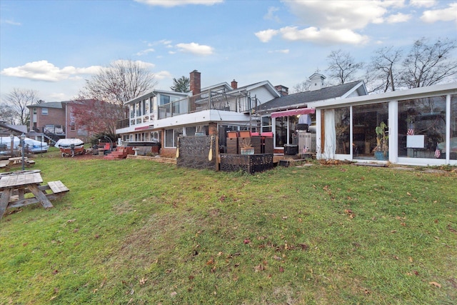 back of house featuring a sunroom, cooling unit, and a yard