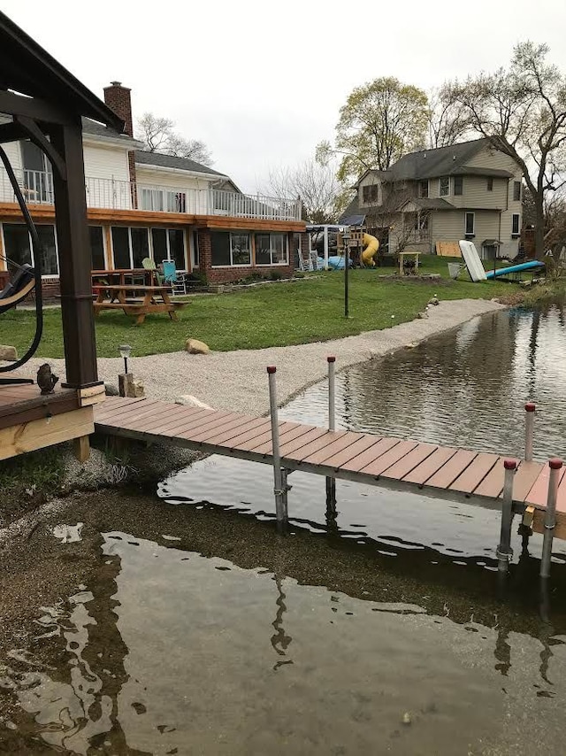 dock area featuring a lawn and a water view